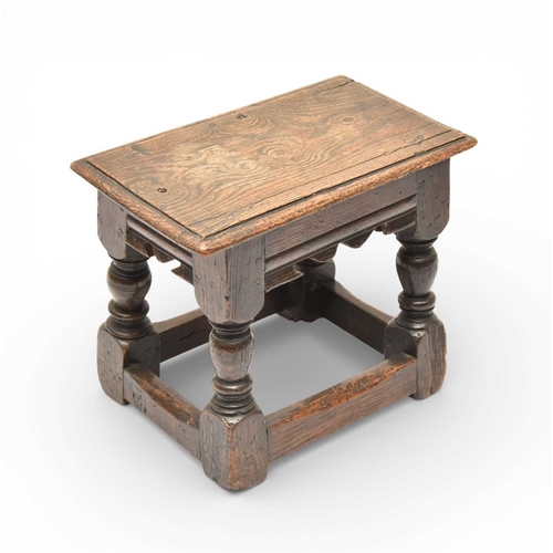 335 - A 17th century oak low joint stool The moulded seat above a channel-moulded frieze with shaped apron... 