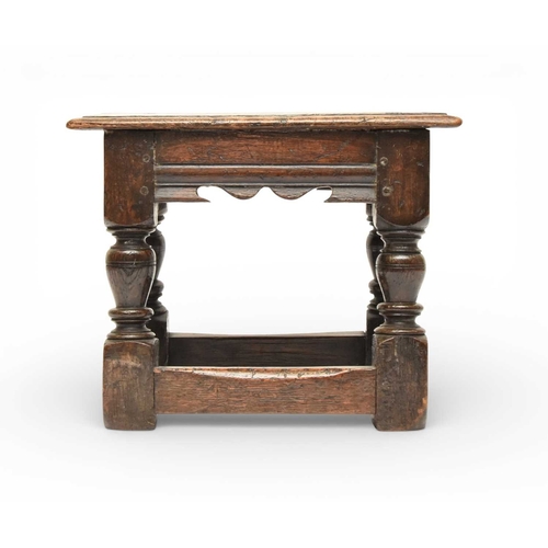 335 - A 17th century oak low joint stool The moulded seat above a channel-moulded frieze with shaped apron... 