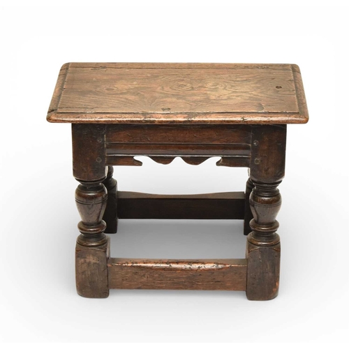 335 - A 17th century oak low joint stool The moulded seat above a channel-moulded frieze with shaped apron... 