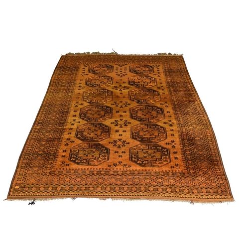 398 - An Afghan Bokkara pattern carpet First half 20th century The central ochre field with multiple 'elep... 