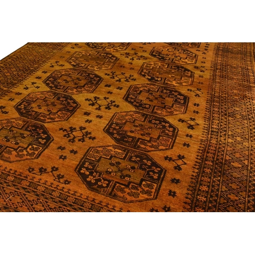 398 - An Afghan Bokkara pattern carpet First half 20th century The central ochre field with multiple 'elep... 