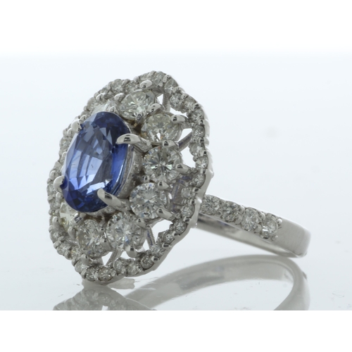 32 - An beautiful oval sapphire is surrounded by a cluster of ten round brilliant cut diamonds which is s... 