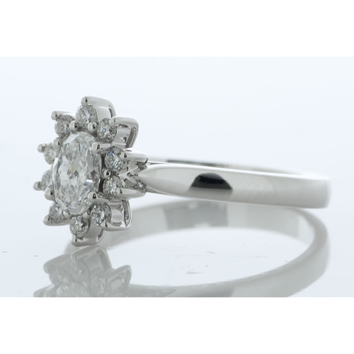 33 - A gorgeous oval diamond is surrounded by a cluster of round brilliant cut diamonds. This stunning 18... 