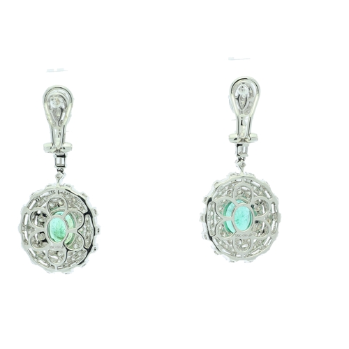 36 - Each of these drop earrings are set with one stunning emerald gemstone sitting in a double halo of f... 