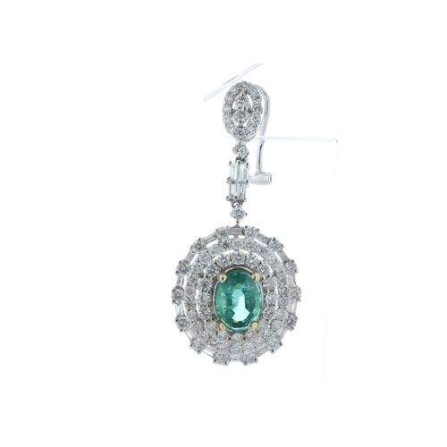 36 - Each of these drop earrings are set with one stunning emerald gemstone sitting in a double halo of f... 