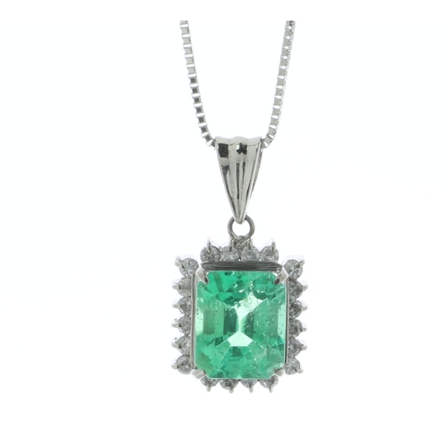 57 - A sparkling emerald cut Colombian emerald sits in a halo of twenty round brilliant cut diamonds on t... 