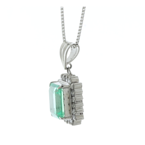 57 - A sparkling emerald cut Colombian emerald sits in a halo of twenty round brilliant cut diamonds on t... 