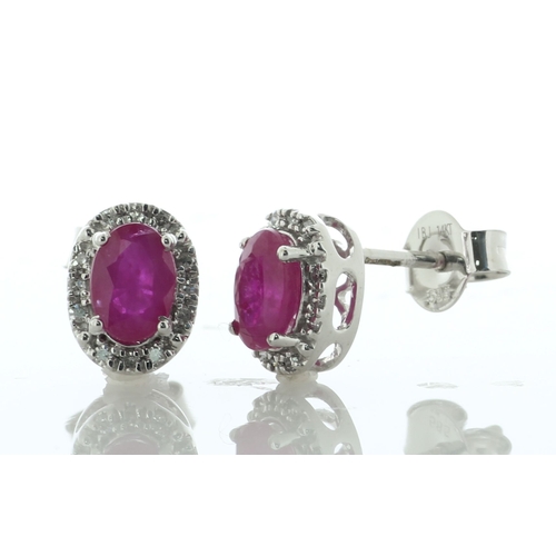 60 - A charming pair of stud earrings, each featuring an oval ruby surrounded by a halo of twelve single ... 