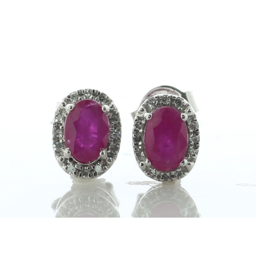 60 - A charming pair of stud earrings, each featuring an oval ruby surrounded by a halo of twelve single ... 