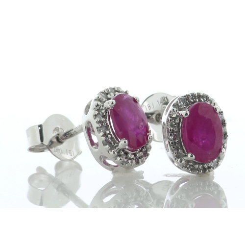 60 - A charming pair of stud earrings, each featuring an oval ruby surrounded by a halo of twelve single ... 