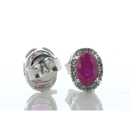 60 - A charming pair of stud earrings, each featuring an oval ruby surrounded by a halo of twelve single ... 