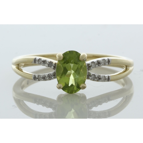 65 - An oval 7mm x 5mm peridot sits between a double band of eight round brilliant cut diamonds set in th... 