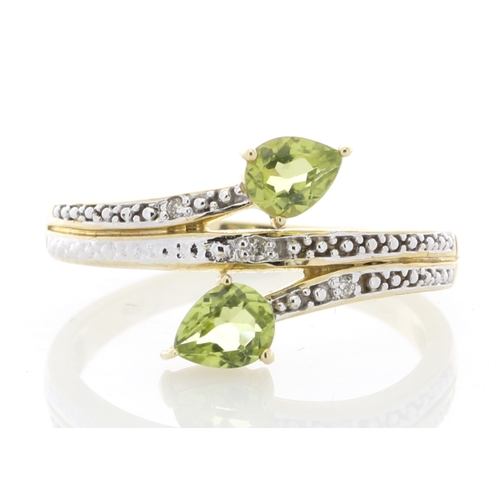 68 - Two pear shaped peridot are set alongside six diamonds on the band and shoulders of this split top 9... 