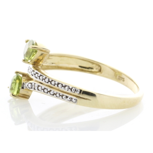 68 - Two pear shaped peridot are set alongside six diamonds on the band and shoulders of this split top 9... 