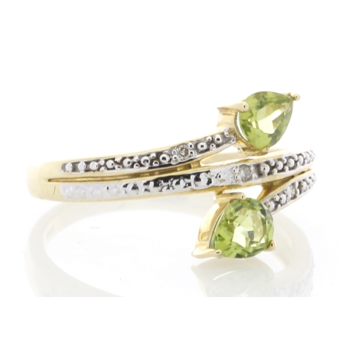 68 - Two pear shaped peridot are set alongside six diamonds on the band and shoulders of this split top 9... 