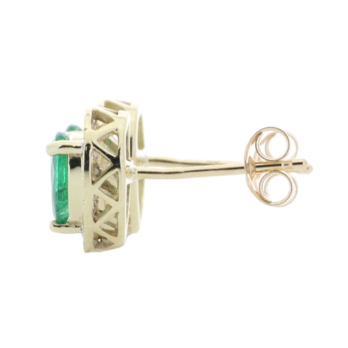 69 - These simple yet classic style stud earrings feature a pear shaped emerald surrounded by a halo of r... 