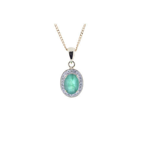 71 - An oval emerald is surrounded by a halo of twenty two round brilliant cut diamonds to create a beaut... 