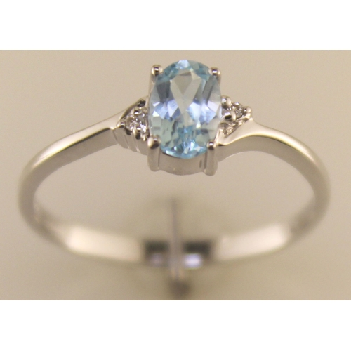 72 - An oval blue topaz is set with one diamond on the shoulder. This 9ct white gold ring is a twist on t... 