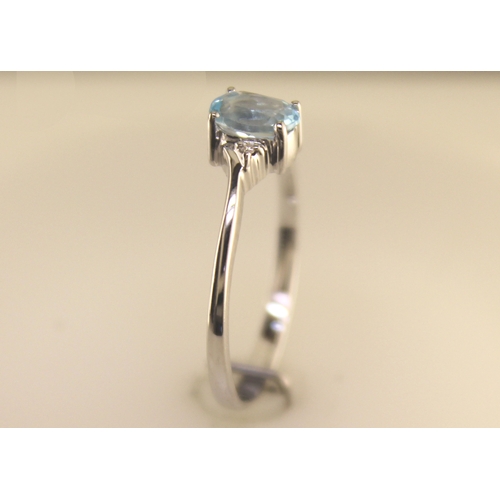 72 - An oval blue topaz is set with one diamond on the shoulder. This 9ct white gold ring is a twist on t... 