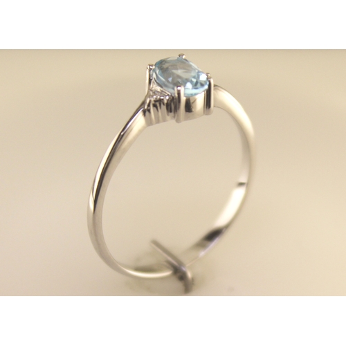 72 - An oval blue topaz is set with one diamond on the shoulder. This 9ct white gold ring is a twist on t... 