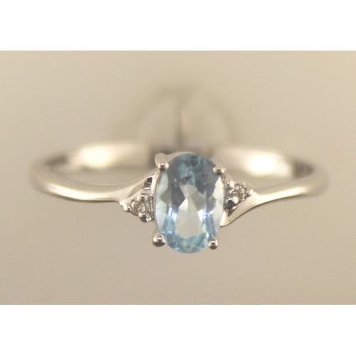 72 - An oval blue topaz is set with one diamond on the shoulder. This 9ct white gold ring is a twist on t... 