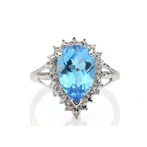 76 - A stunning pear shaped Blue Topaz 3.23 carats sits surrounded by a halo set with four single cut dia... 