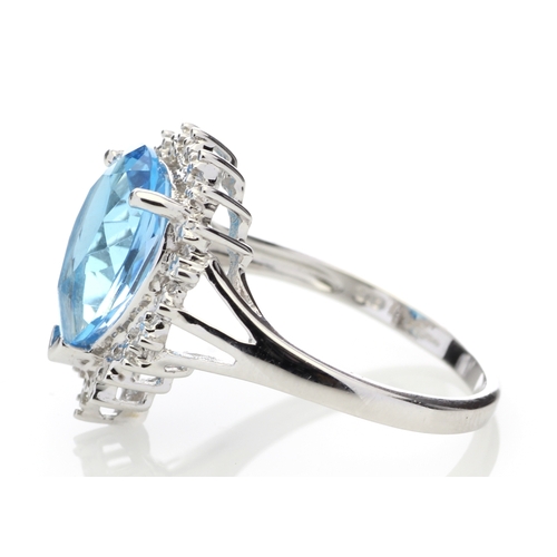 76 - A stunning pear shaped Blue Topaz 3.23 carats sits surrounded by a halo set with four single cut dia... 