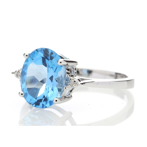 80 - An oval cut Blue Topaz 2.10 carats sits between two round brilliant cut diamonds in this gorgeous 9c... 