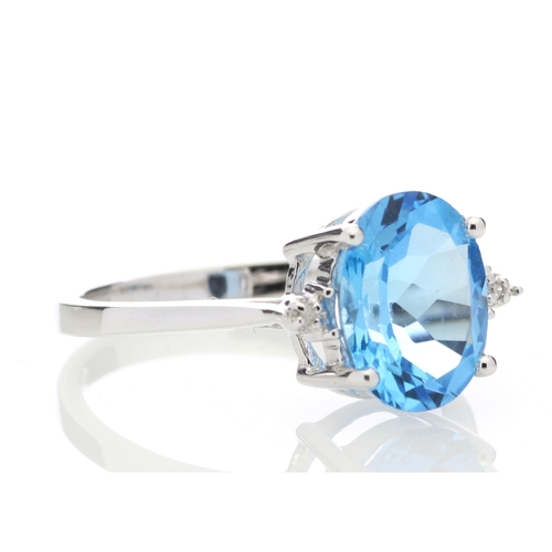 80 - An oval cut Blue Topaz 2.10 carats sits between two round brilliant cut diamonds in this gorgeous 9c... 