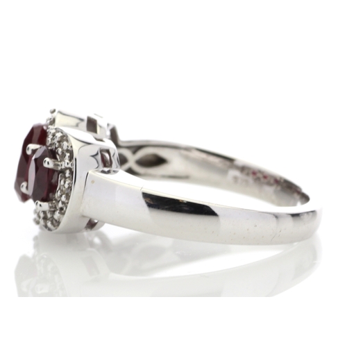 83 - Three oval created rubies are surrounded by a cloud halo of diamonds in this 9ct white gold diamond ... 