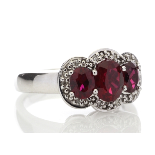 83 - Three oval created rubies are surrounded by a cloud halo of diamonds in this 9ct white gold diamond ... 