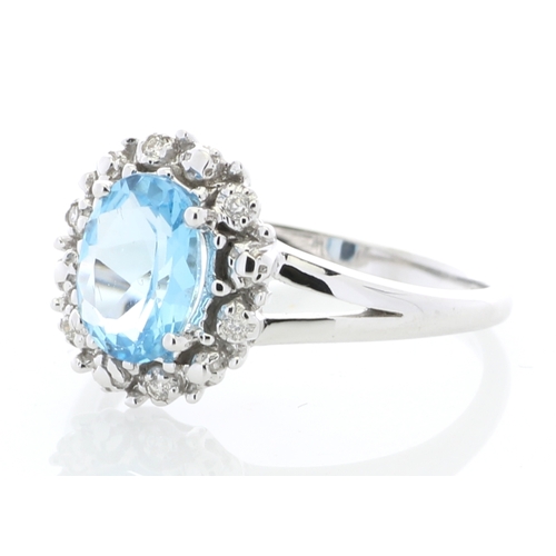 84 - An oval blue topaz is surrounded by a halo or diamonds on this stunning 9ct white gold split shank d... 