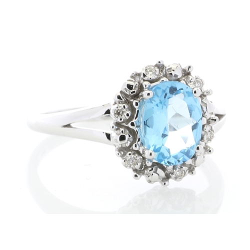 84 - An oval blue topaz is surrounded by a halo or diamonds on this stunning 9ct white gold split shank d... 