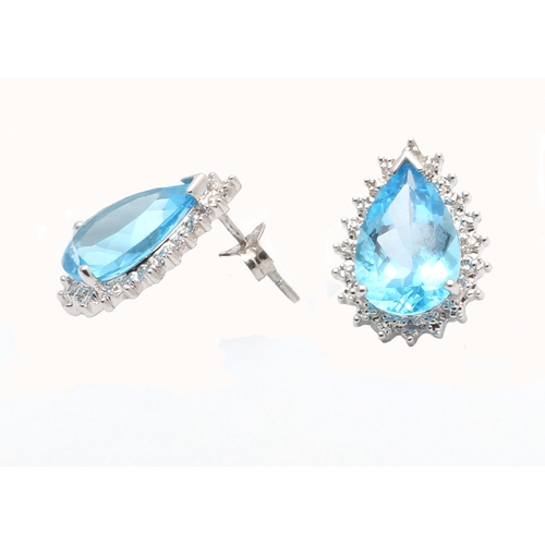 92 - Two pear shaped blue topaz gemstones are surrounded with a halo of diamonds in this stunning stud ea... 