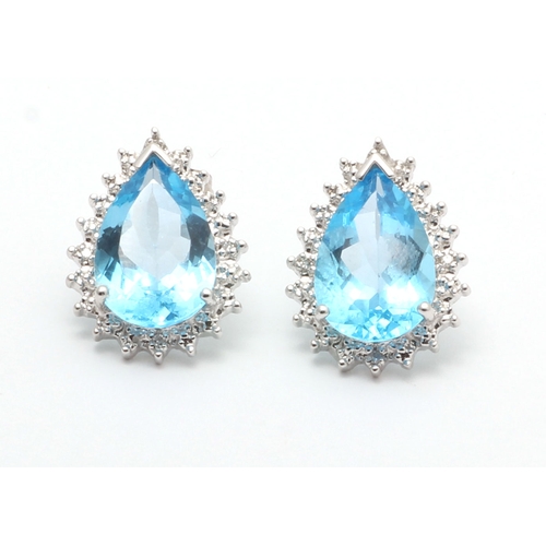 92 - Two pear shaped blue topaz gemstones are surrounded with a halo of diamonds in this stunning stud ea... 