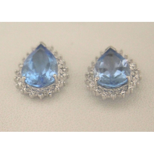 92 - Two pear shaped blue topaz gemstones are surrounded with a halo of diamonds in this stunning stud ea... 