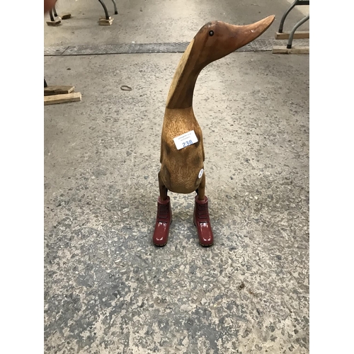 238 - A WOODEN MODEL DUCK WEARING PURPLE HIKING BOOTS, 46CM HIGH