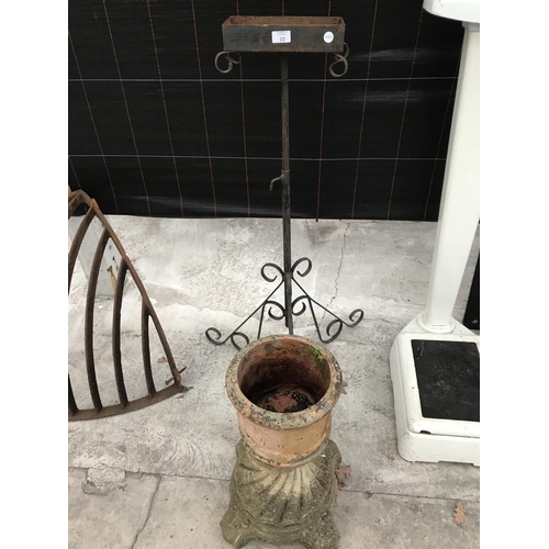 10 - A TERRACOTTA PLANTER ON A CONCRETE PLINTH AND A WROUGHT IRON PLANT STAND