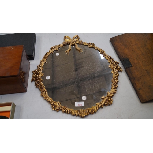 425 - A GILT FRAMED DECORATIVE CIRCULAR WALL MIRROR WITH BOW TIE FINIAL DESIGN