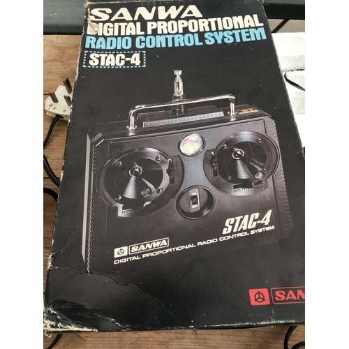 129 - THREE ITEMS - A SANWA STAC 4 DIGITAL PROPORTIONAL RADIO CONTROLLER, A PS 2 AND A PS 1