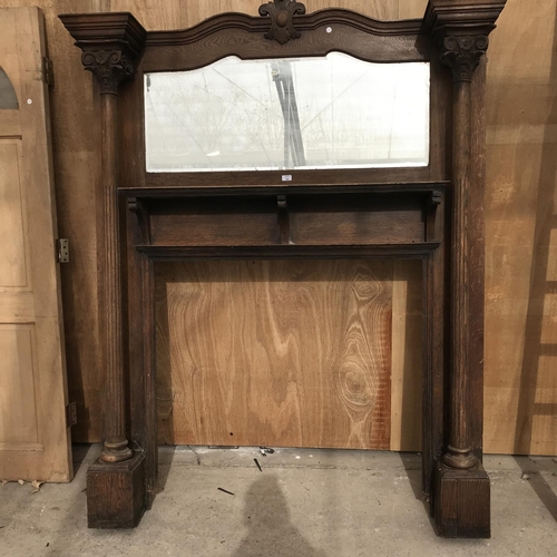 46 - AN OAK FIRE SURROUND WITH BEVEL EDGE OVER MANTLE MIRROR