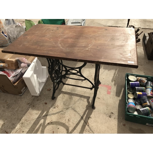 24 - A WOODEN TOP TABLE ON A CAST IRON SEWING MACHINE FRAME 113CM X 60.5CM