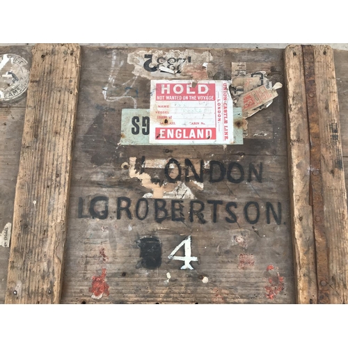 93 - A VINTAGE WOODEN CHEST WITH METAL HANDLES, METAL LINED WITH VARIOUS STICKERS