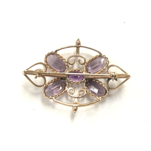 754 - A LADIES 9CT YELLOW GOLD EDWARDIAN BROOCH WITH CENTRAL AMETHYST STONE AND FOUR FURTHER PINK STONES