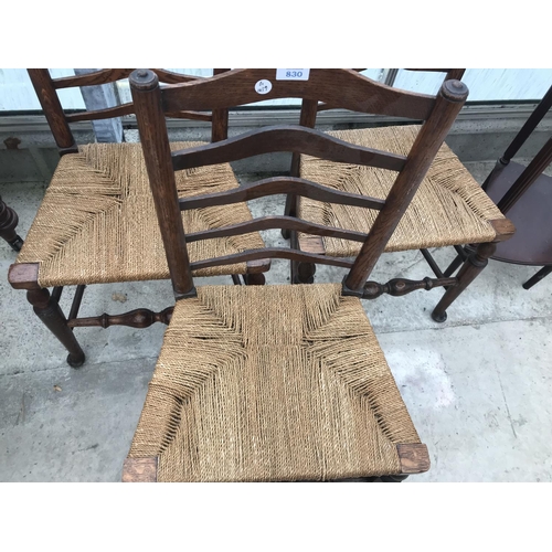 830 - THREE OAK LADDER BACK DINING CHAIRS WITH RUSH SEATS