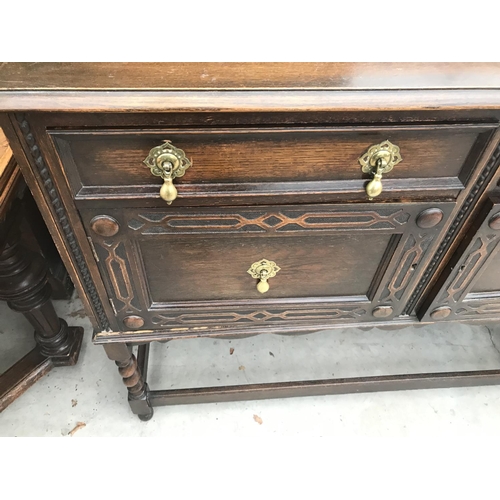 848 - AN OAK SIDEBOARD ON BARLEY TWIST SUPPORTS WITH STRETCHER RAILS WITH TWO DOORS AND TWO DRAWERS WITH B... 