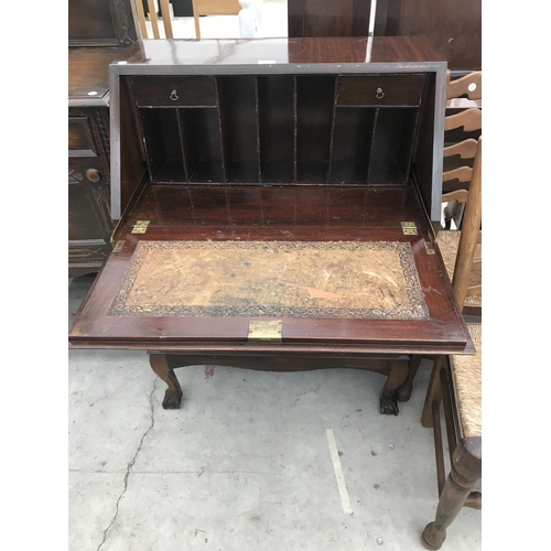 849 - A MAHOGANY BUREAU ON BALL AND CLAW FEET WITH FALL FRONT AND THREE DRAWERS