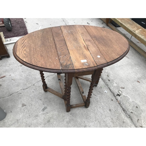 981 - AN OVAL OAK DROP LEAF SIDE TABLE ON BARLEY TWIST SUPPORTS