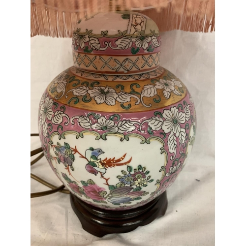 25 - AN ORIENTAL TABLE LAMP DEPICTING FLOWERS AND BIRDS ON A WOODEN BASE