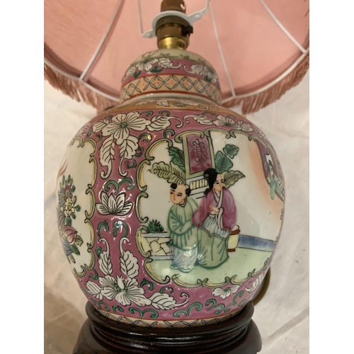 25 - AN ORIENTAL TABLE LAMP DEPICTING FLOWERS AND BIRDS ON A WOODEN BASE